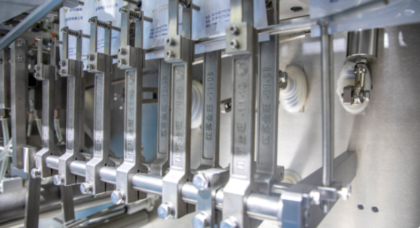 Machine de remplissage de liquide à piston intégrant la formation de sacs de remplissage, l'étanchéité et le transport du produit fini dans un seul système